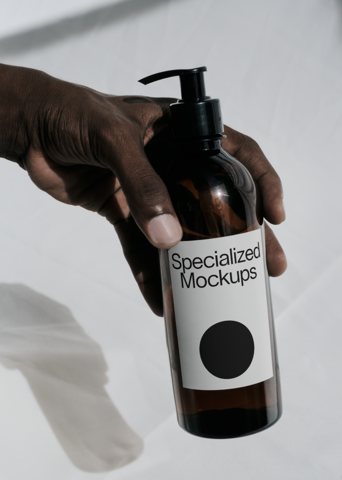 Hand holding a labeled dispenser bottle mockup with shadow, ideal for product packaging and branding design projects for designers.